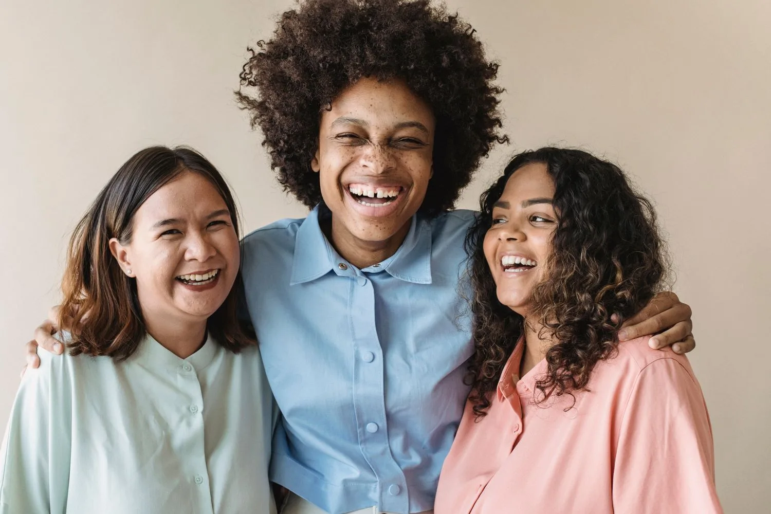 Three women of different ethnicities laughing together